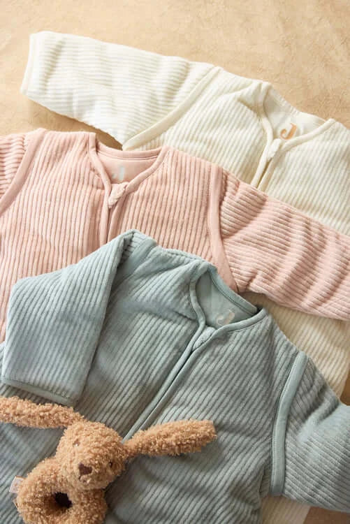 Soft ribbed baby sleep bags in pastel colors, perfect for cozy and stylish infant sleep time.