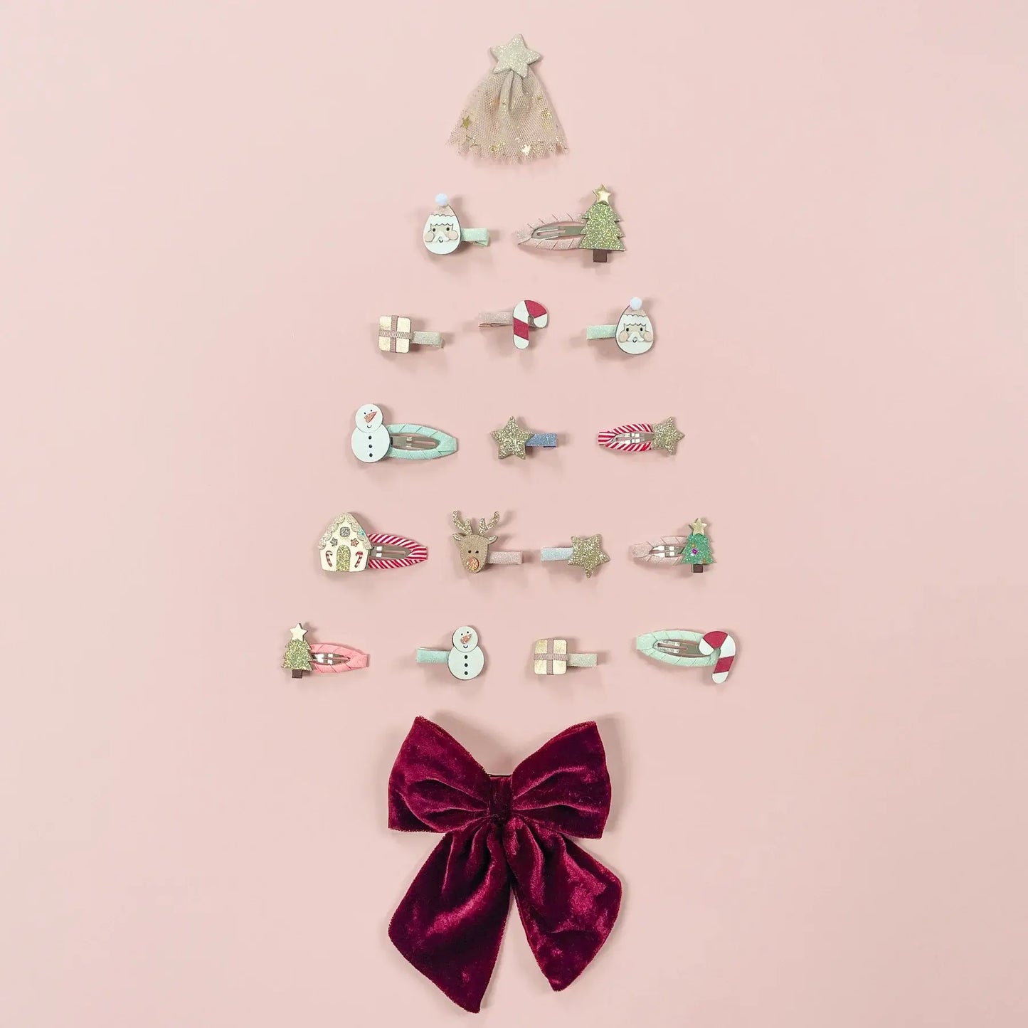 Festive mini hair clips arranged like a Christmas tree, featuring reindeer, snowmen, and glittery stars.