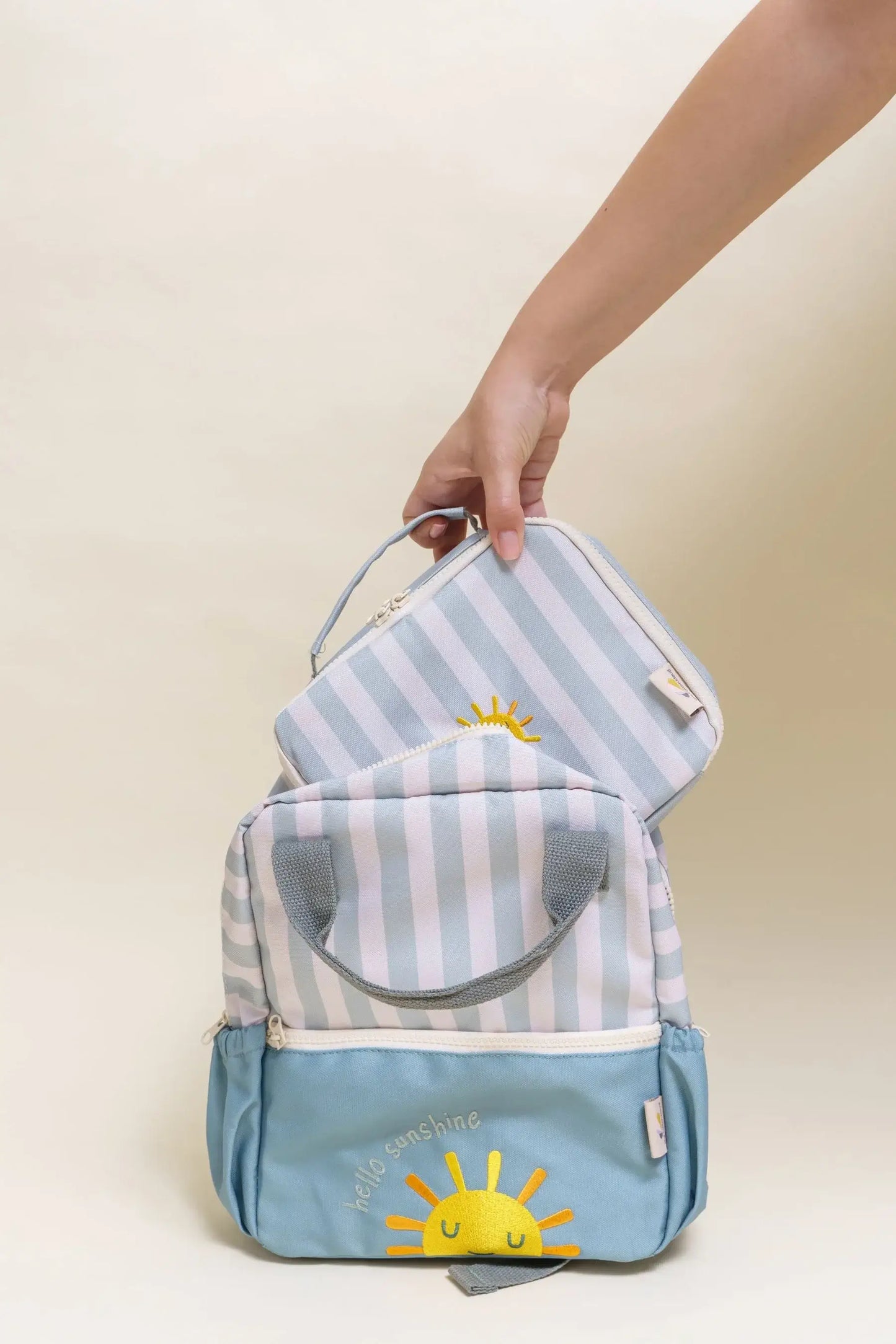 Hand holding Cotton Cloud insulated cooler bags with sunny designs, perfect for keeping meals fresh on the go.
