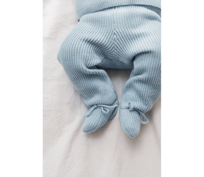 Soft blue knitted newborn pants with elastic waistband and tied cuffs, made from 100% organic cotton.