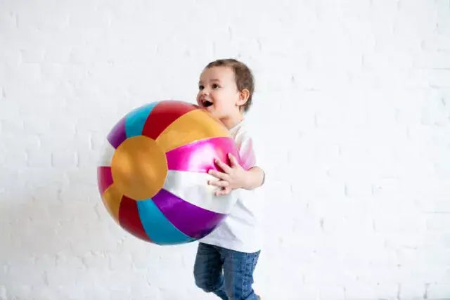 Een vrolijk kind met een kleurrijke Ratatam! circusbal van 40 cm, perfect voor binnen speelplezier.