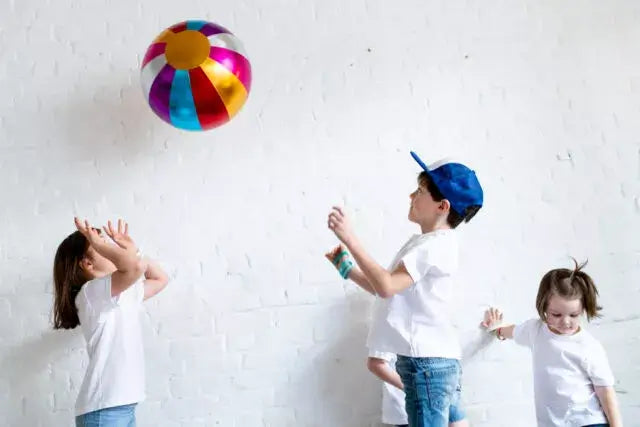 Kids playing with a colorful Ratatam! Circus Bal indoors, showcasing fun and laughter in bright hues.