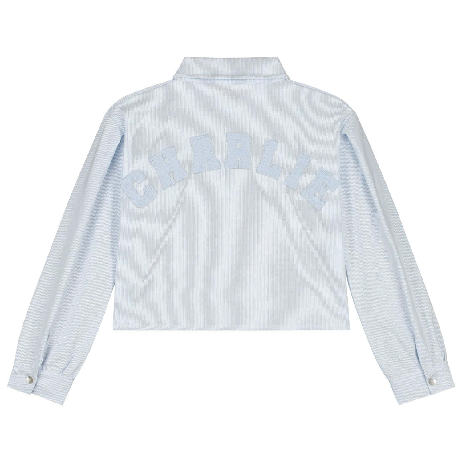 Back view of Charlie Petite Gaby Blouse in light blue with white lettering, perfect for stylish girls' fashion.