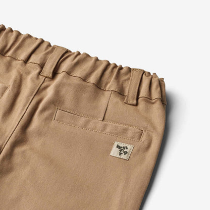 Detail of Wheat Jongens Broek Hugo in cappuccino, featuring elastic waistband and back pocket design.