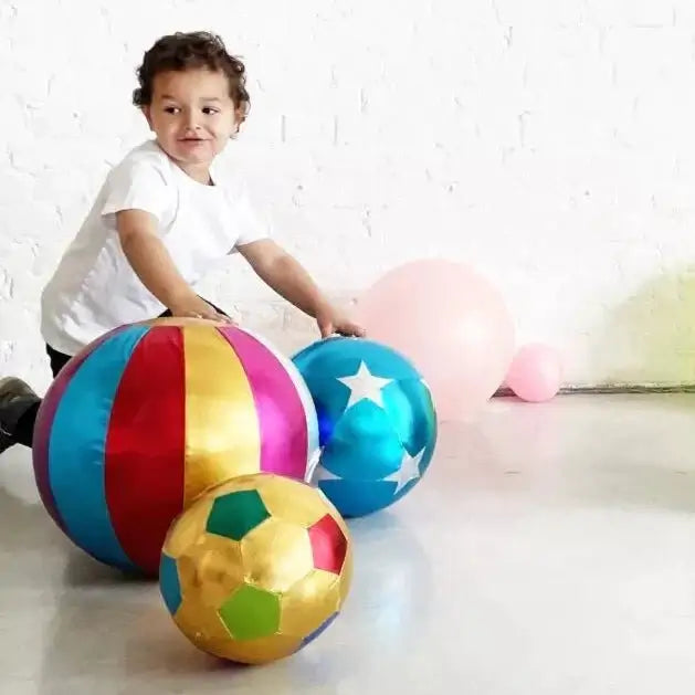 Kind speelt met kleurrijke zachte ballen, perfect voor actief speelgoed en plezier in huis of op het strand.